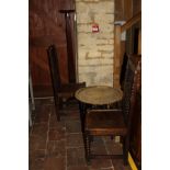 A pair of oak hall chairs with carved backs, on bobbin turned legs united by stretchers,