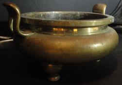 A 19th Century Chinese brass censer of squat form with two handles, raised on three legs,