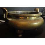 A 19th Century Chinese brass censer of squat form with two handles, raised on three legs,