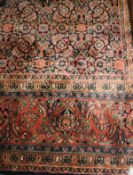A Persian carpet, the central panel set with all over floral design on a blue ground,