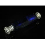 A Victorian white metal mounted double-ended scent bottle, the body of blue glass with facet cuts,