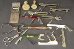 A collection of various corkscrews, wire cutters, can openers, sugar tongs,