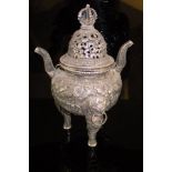 An Indian white metal censer, the pierced top with floral decoration,