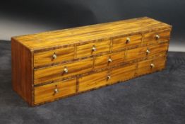 An early 19th Century mahogany dwarf bank of ten drawers with barber pole strung and cross banded