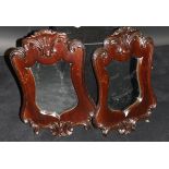 A pair of shield shaped wall mirrors with mahogany frame in the Rococco taste,