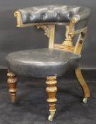A Victorian mahogany framed buttoned yoke back library chair in black leather upholstery with