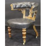 A Victorian mahogany framed buttoned yoke back library chair in black leather upholstery with