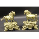 A pair of late 19th century brass chenets in the form of a horse upon a base in the Louis XV Rococo