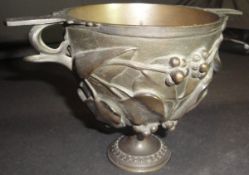 A Victorian bronze trophy cup with heavy relief work, ivy and berry decoration,