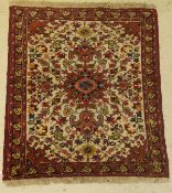 A Caucasian rug, the central panel set with all over floral design on a cream ground,
