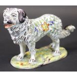 A late 19th/early 20th Century French faience figure of a stylised Pyrenean Mountain Dog with all