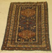 A Caucasian rug, the central panel with three lozenge shaped medallions on a blue ground,