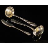 A pair of modern Italian silver sauce ladles with stylised twist handles, terminating to shell ends,