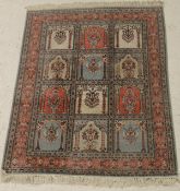 A silk rug, the central panel set with three rows of four panels,