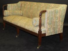 A late George III mahogany framed three seat settee with cream ground foliate patterned upholstery,