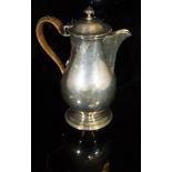 An Edwardian silver baluster shaped water jug with caned handle in the Georgian taste (by Skinner &