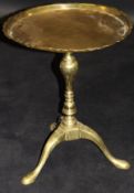 A 19th Century brass tripod wine table with dished top,