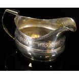 A George III Irish silver milk jug with engraved foliate and fruit decorated band (maker's mark
