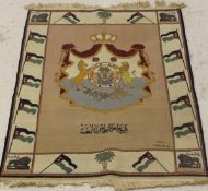 An Iraqi wall-hanging rug, the centre field with the crest of the Iraqi Royal family,