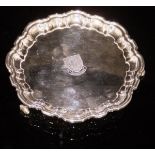 A modern silver card tray with pie-crust style edge, raised on three scrolling feet,