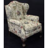 An early 19th Century wing back armchair with modern crewel work upholstery,