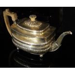 A late George III silver teapot of banded rectangular bellied form with semi-reeded decoration and