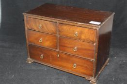 A 19th Century miniature mahogany chest with four short and one long drawer on ogee bracket feet