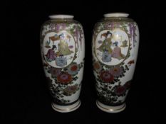 A pair of Japanese Satsuma vases with panels of figures in interior settings amongst trailing