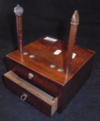 A mahogany wool winder with two pegs on a square heavy mahogany base,