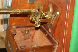 A circa 1900 lacquered brass cased microscope and various slides in a mahogany case,