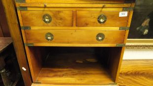 A pair of yew wood Campaign style bedside cabinets with brushing slide and leatherette inset top