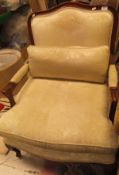 A mahogany framed armchair in pale yellow foliate patterned upholstery,