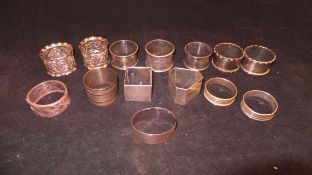 A collection of fourteen silver and white metal napkin rings