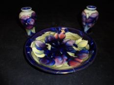 A pair of small Moorcroft Burslem pottery baluster shaped vases decorated in a "Pansy" pattern and
