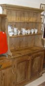 A 19th Century pine dresser with moulded pediment above a waterfall two tier plate rack,