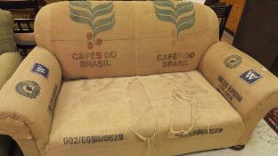 A hessian covered scroll arm sofa raised on bun feet