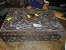 A mahogany Eastern carved box with carved top featuring a dragon