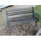 A two seat garden bench with green painted iron frame, a matching table,