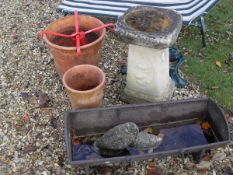 A composite stone bird bath, two terractotta planters, acast iron animal feeder,