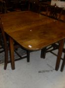 A 19th Century oak rectangular drop-leaf dining table with rounded corners,