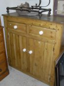 A pine cupboard of two drawers above two panelled cupboard cupboard doors,