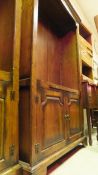 An oak bookcase with moulded cornice above two open adjustable shelves with brushing slide beneath