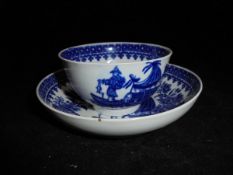 An 18th Century Worcester 'Fisherman with fish on a punt' tea bowl and saucer bearing blue crescent