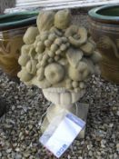 A composite stone garden ornament of fruit in urn