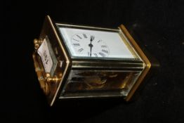 A circa 1900 French brass cased carriage clock with visible escapement,