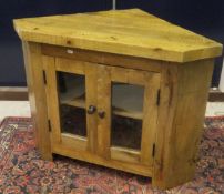 A hardwood corner tv stand with two glazed doors enclosing shelves,