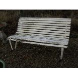 A cream painted wooden slatted bench with iron supports