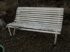 A cream painted wooden slatted bench with iron supports