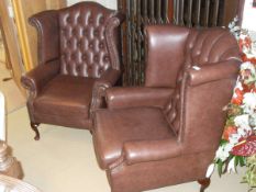 A pair of modern brown leather button back wing arm chairs on mahogany cabriole legs