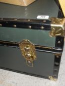 A trunk in green with brass studs and brass locks